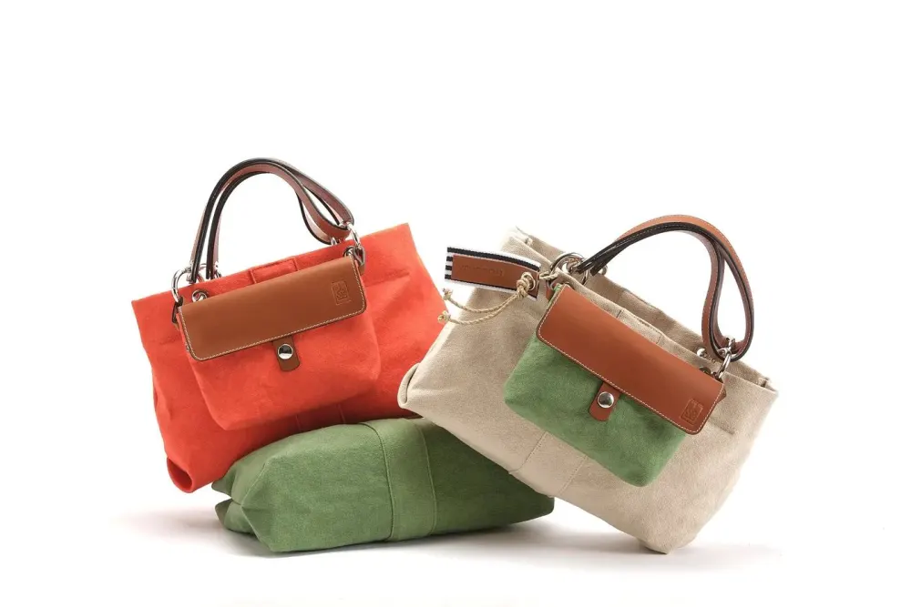 Sacs à main colorés en toile et cuir, un modèle beige avec pochette verte et un modèle orange avec pochette marron.