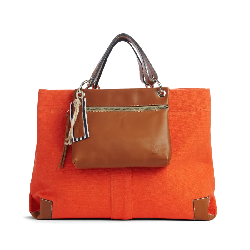 pochette yole en cuir naturel gold accrochee sur un sac canotage working corail
