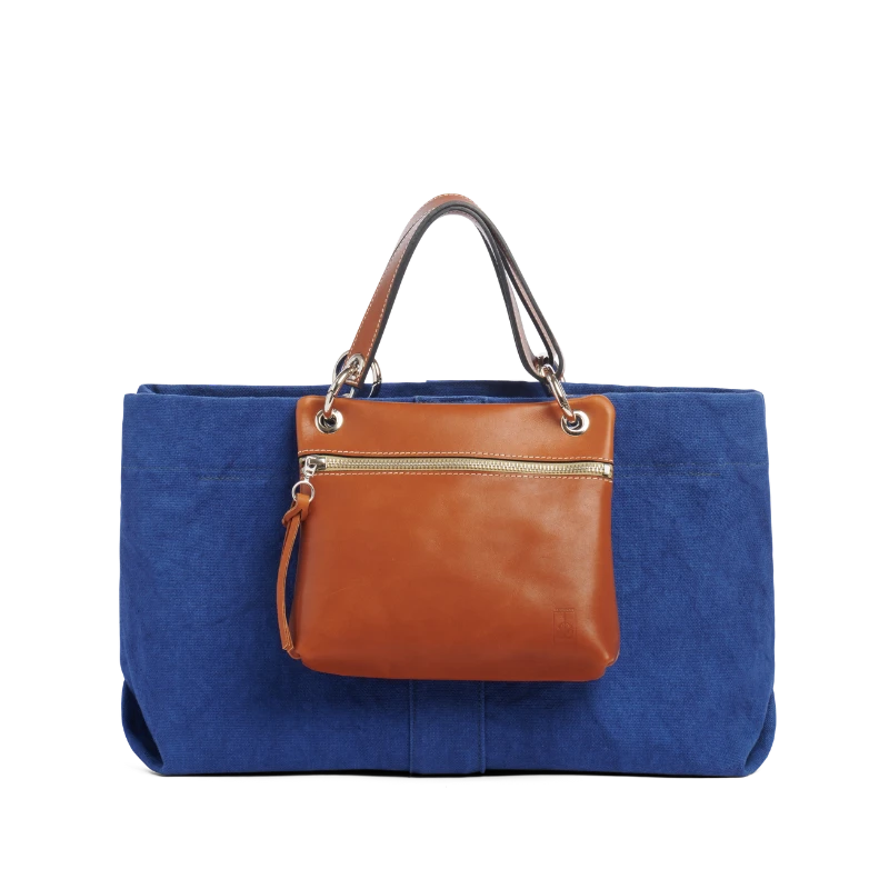 pochette yole en cuir naturel gold accrochee sur un sac canotage medium bleu roi